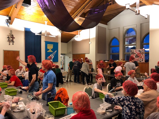 group of people packing food for Rise Against Hunger