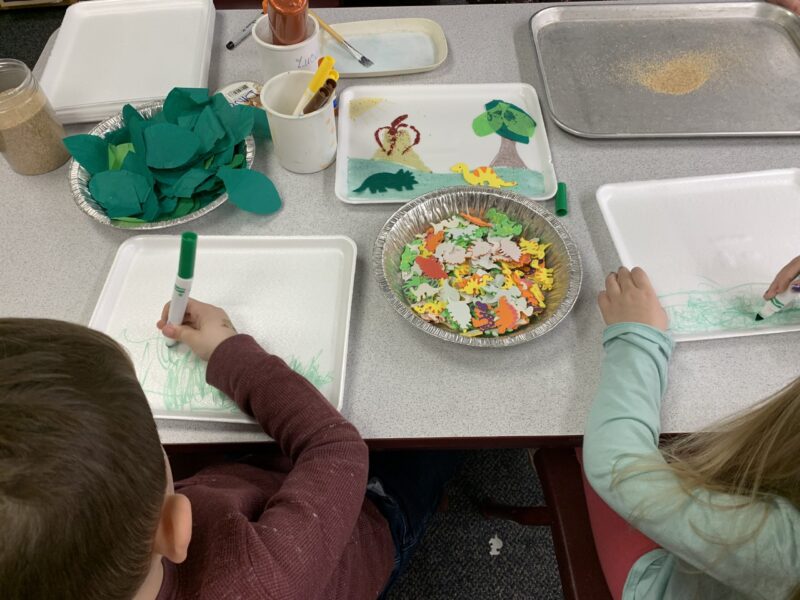 preschool children at a table making craft projects