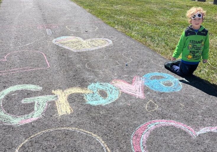 Outdoor chalk drawing and the child who made it